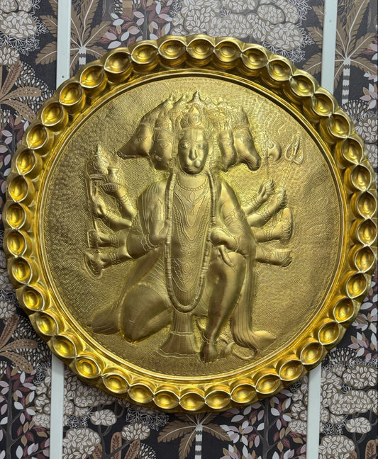 Bronze decorative plaque with a central figure on a patterned background